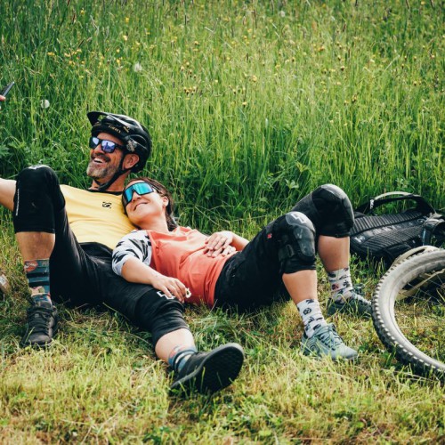 Een stel die met de mountainbike in het gras liggen